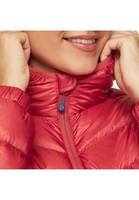 Czerwona kurtka puchowa z wysokim kołnierzem, pikowanym wzorem i niebieskim uchwytem zamka. Materiał kurtki ma gładkie, błyszczące wykończenie.