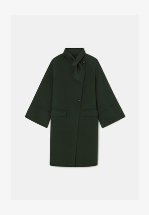 Palton verde închis cu un design tip wrap, având un guler legat, buzunare mari în față și mâneci largi. Fabricat dintr-un material moale cu o textură netedă.