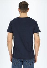 T-shirt in cotone blu navy con collo rotondo classico e maniche corte, mostrato da dietro, caratterizzato da una texture liscia e un design minimale.