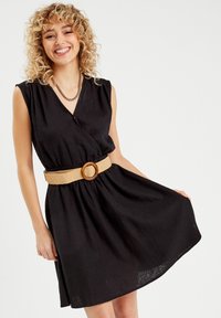 Vestito nero a portafoglio con maniche corte, vita arricciata e una cintura intrecciata beige con una fibbia di legno rotonda. Tessuto dalla texture liscia.