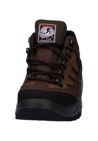 Brauner Trekkingschuh mit robustem Design, strukturiertem synthetischem Obermaterial, Gummisohle und kontrastierenden schwarzen Akzenten. Verfügt über ein Schnürsystem und ein Logotag.