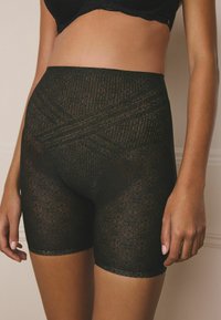 Black lace shorts featuring intricate circular patterns and a smooth texture, designed for a comfortable fit and modest coverage.
