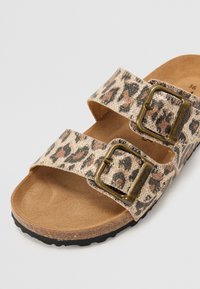 Sandal med leopardprint og to justerbare remme, metalspænder og en polstret fodseng. Tekstiler overdel med en brun gummisål.