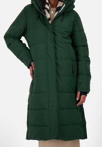 Abrigo largo acolchado verde con capucha, con cremallera frontal, bolsillos laterales y botones a presión. Textura suave con diseño acolchado.