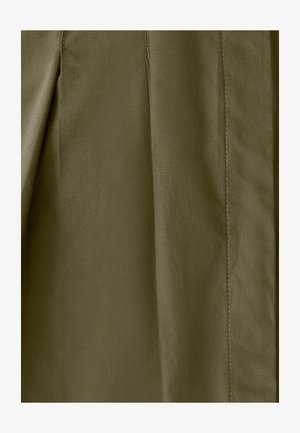 Olivově zelená tkanina s hladkým povrchem, na které jsou viditelné stehy a sklady, vytvářející strukturovaný design.