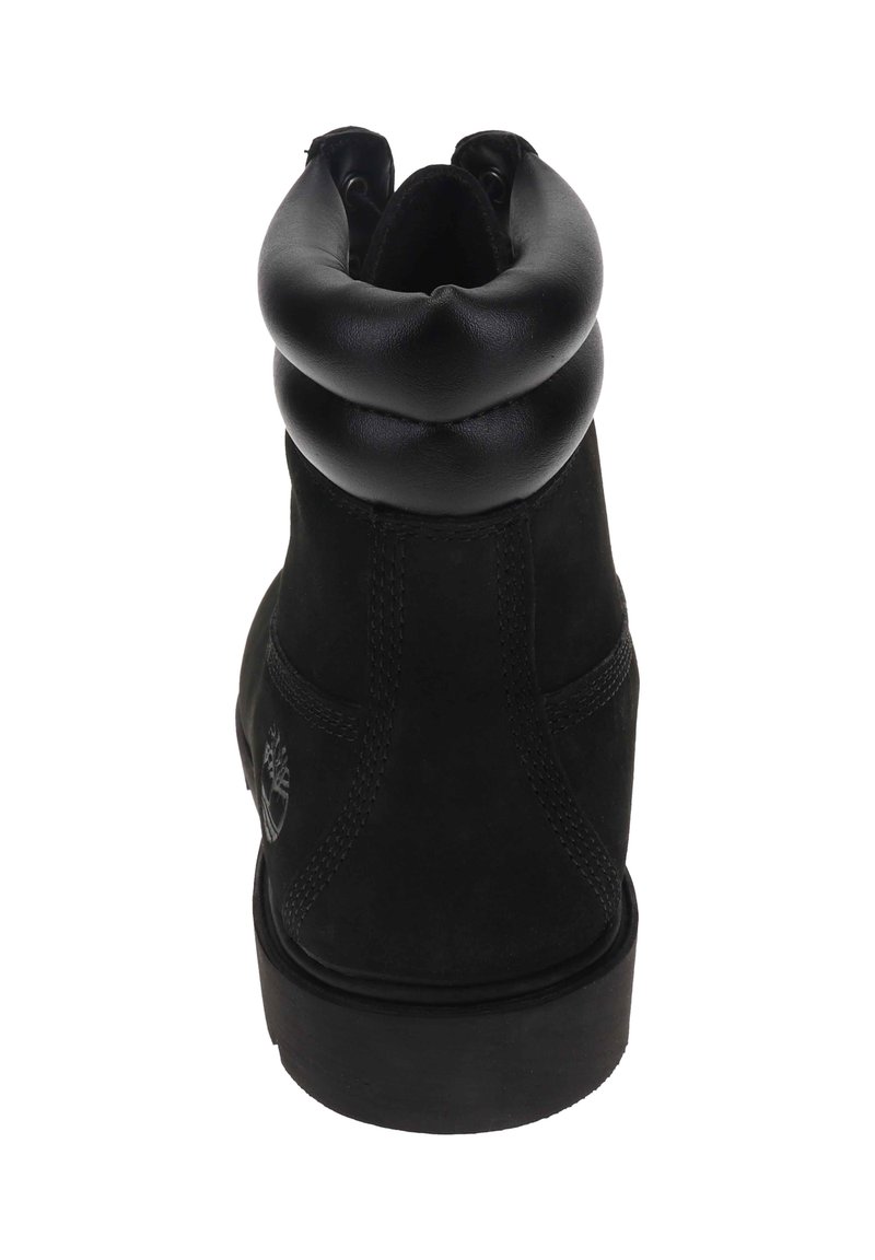 Schwarze Knöchelboots mit einem runden Schaft, aus Leder und Wildleder gefertigt, mit sichtbaren Nähten und einer Gummisohle. Timberland-Logo an der Seite geprägt.