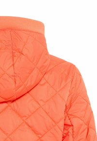 Gequilted oranje jack met capuchon, featuring een geribde halslijn en een gladde textuur, met een diamantpatroon in de stitchdetails.