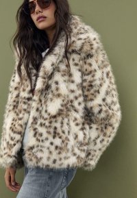 Lažna krznena jakna s uzorkom leopard, u krem i smešnim bojama, sa širokim ovratnikom i dugim rukavima. Tekstura je meka i pahuljasta.