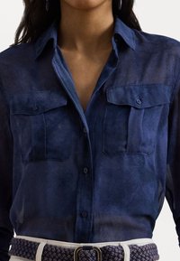 Navy blue, sheer button-up shirt with two chest pockets and a classic collar. Features smooth fabric and subtle gradient texture.
