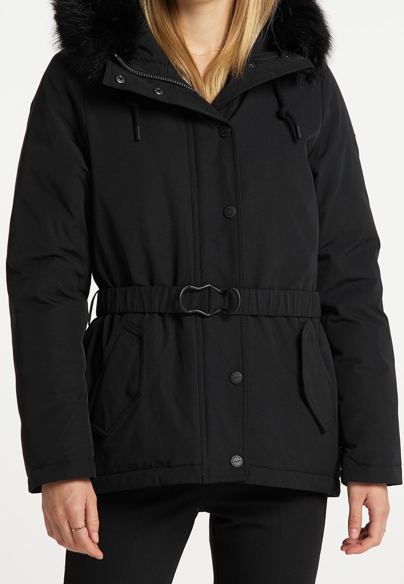 Chaqueta acolchada negra con capucha desmontable forrada de piel, cintura con cinturón, cierre de botones y bolsillos laterales. Textura suave con detalles de costuras.