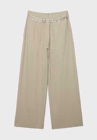 Pantalon beige à jambes larges avec une taille haute, orné d'une ceinture en chaîne argentée avec des maillons circulaires, posé à plat sur un fond blanc.