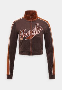 Veste cropped en velours marron et rouille avec fermeture éclair intégrale, col haut, passepoil blanc sur les manches et texte en cursive "Jaded Ldn" à l'avant.