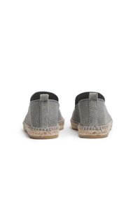 Espadrilles de tela gris con textura tejida y paneles laterales elásticos. Presentan una suela de cuerda de yute y una base de goma plana para mayor tracción.
