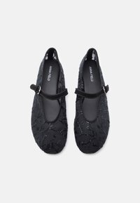 Μαύρες μπαλαρίνες με σουέτ λουρί, διακοσμημένες με μαύρες παγιέτες και κεντημένα σχέδια φύλλων σε υφασμάτινη υφή.