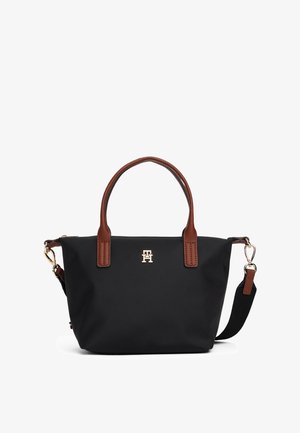Mustast nailonist käekott pruuni nahkkäepideme ja detailidega, kuldse logoga ees, eemaldatava õlarihma ja struktureeritud disainiga.