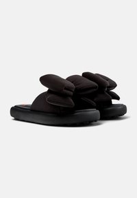 Mustad mustad sandaalid, mille rihmad on kaunistatud kahe ülekaaluka, pehme kangast kaarega, must pehmendatud tald ja tekstuuriga välistald haardeks.