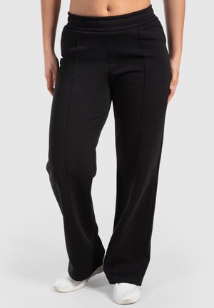 Pantalones de chándal negros hechos de tela suave, con un diseño de pierna ancha, una cintura elástica y sutiles detalles de costura.