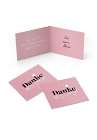 Roosa kaartide komplekt, mille esiküljel on paksu musta tähtedega "Danke". Sees on kirjutamiseks ruumi, pehme roosa tausta ja dekoratiivse tekstiga.