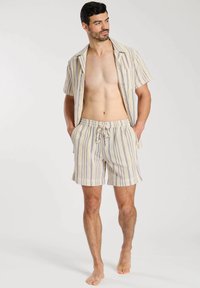 Kortärmad randig skjorta med knappar och matchande shorts i kräm, blått och gult. Lätt material, avslappnad passform, dragsko i midjan.