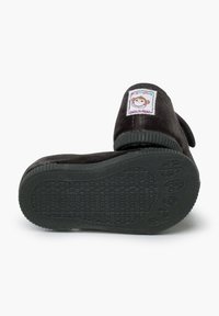 Zwarte stoffen pantoffel met een gestructureerde zool, met een apenlabel op de hiel. Ronde vorm met een fluweelachtige afwerking.