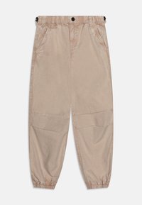 Pantalons tapered beige clair avec taille élastique, poches latérales et poignets froncés. Fabriqués dans un tissu lisse et légèrement brillant.