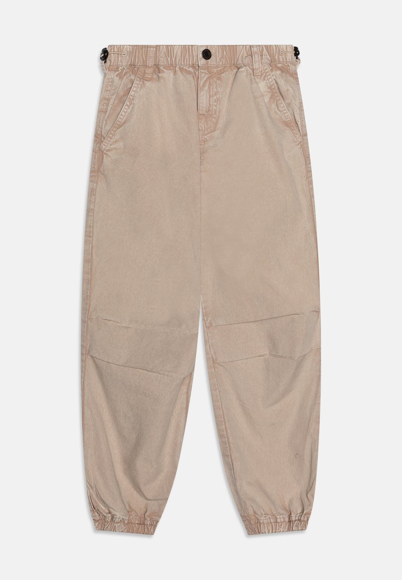 Pantalons tapered beige clair avec taille élastique, poches latérales et poignets froncés. Fabriqués dans un tissu lisse et légèrement brillant.