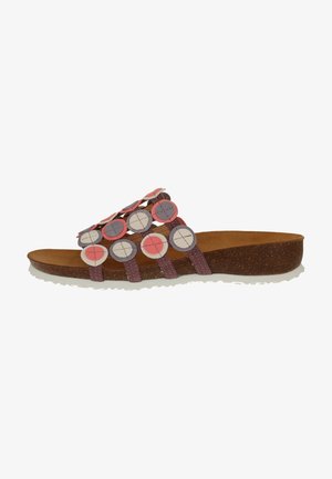Ein Paar flache Sandalen mit einer braunen Korksohle, lila Riemen und dekorativ angeordneten, runden Filz-Akzenten in Pink, Grau und Creme.