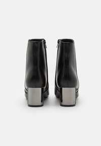 Svarta läderankelstövlar med en elegant design, dragkedjestängning och glänsande silverblockklackar. Slät yta med minimala sömdetaljer.