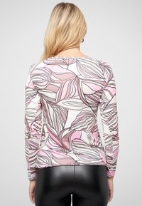 Langärmliges Oberteil mit pinkem Blumenmuster und schwarzen Konturen, aus leichtem Stoff gefertigt. Verfügt über einen runden Ausschnitt und eine enganliegende Silhouette.
