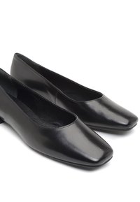 Ballerines en cuir noir avec un bout carré, design facile à enfiler, texture lisse et petit talon. Aucun élément métallique ni motifs visibles.