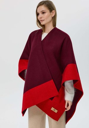 Poncho in lana bordeaux e rosso con un design a strati, dotato di scollo a V, maniche larghe e una patch con logo ricamata sull'orlo.