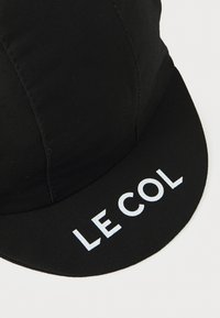Cappellino da ciclismo nero in tessuto testurizzato, con visiera curvata e logo "LE COL" in bianco sul davanti. Design semplice e funzionale.