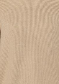 Beige gebreide stoftextuur met een ribbelontwerp en een zachte, gestructureerde oppervlakte. Homogene kleurverdeling zonder patronen of accenten.