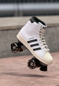 Patins de roda de alta branca com parte superior em couro texturizado, três riscas pretas e rodas pretas com a marca "adidas".