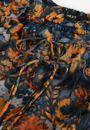 Gėlių rašto marškinėliai, kuriuose vyrauja mėlyni, oranžiniai ir geltoni atspalviai, pagaminti iš lengvo audinio. Sukurti su surinktu dekolte ir dekoratyvinėmis virvutėmis.