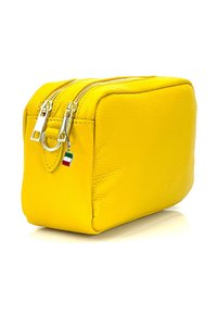 Geel lederen cosmetica tas met een rechthoekige vorm, zilveren ritsen en een klein Italiaans vlag charm eraan bevestigd. Gladde textuur, minimalistisch ontwerp.