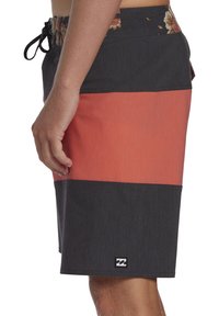Pantaloni da surf con un design a righe grigio scuro e corallo, dotati di una cintura a fantasia floreale e un piccolo logo applicato all'orlo.