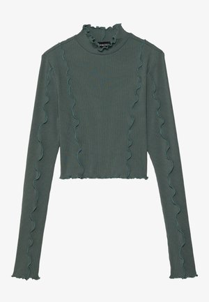 Green ribbed long-sleeve top with a high neck, featuring ruffled edges and contrasting teal stitching along the seams. Cropped design.