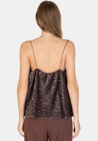 Top marrone con paillettes, spalline sottili, vestibilità ampia e texture scintillante, con design a schiena scoperta per un look elegante.