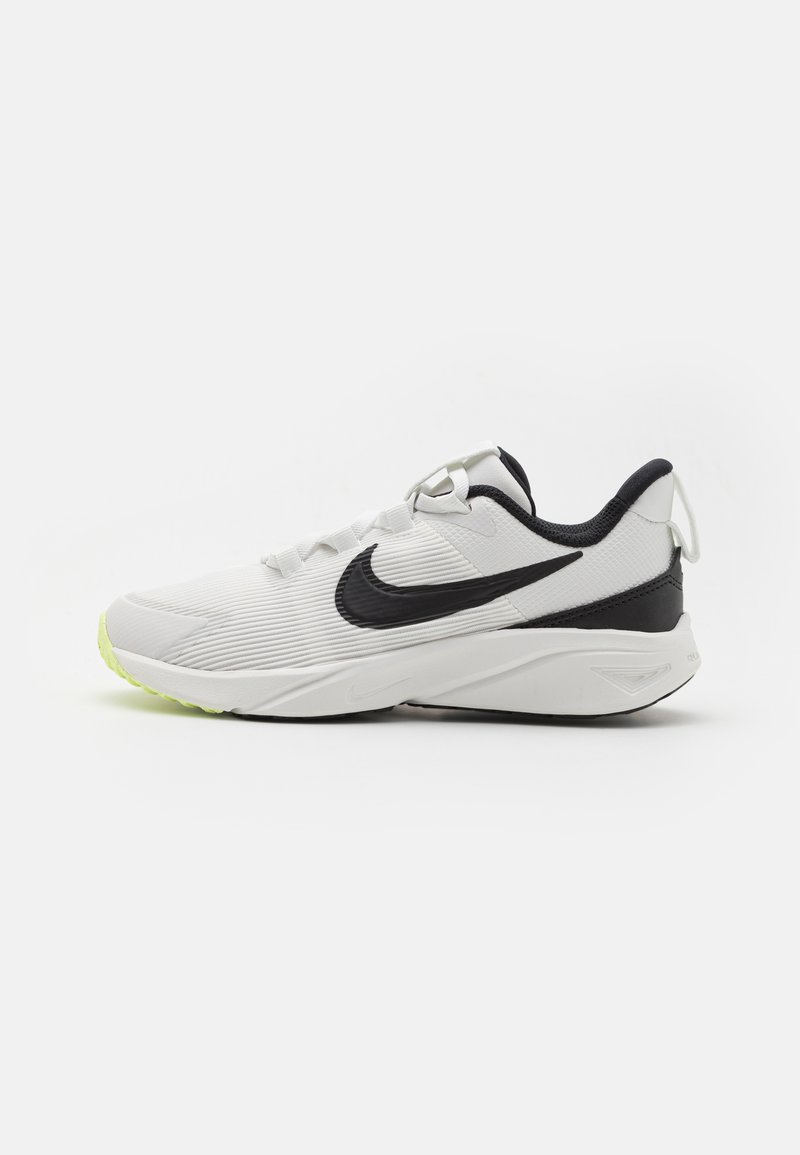 Weißer Sportschuh mit strukturiertem Obermaterial, schwarzen Akzenten, sicherem Schnürsystem und neongrüner Sohle. Verfügt über ähnliche Designelemente auf beiden Seiten.