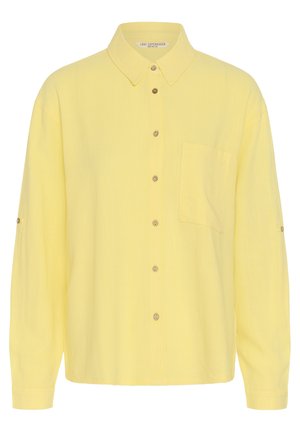 Dzeltena krekla ar garām piedurknēm, apkakli, krūšu kabatu priekšpusē un pogām vidū un uz piedurknēm.