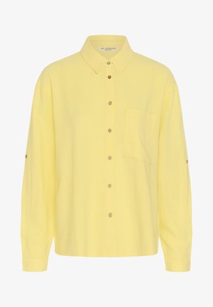 Pikkade varrukatega kollane nööbitav särk kraega, esiküljel rinnatasku ning nööbid keskel ja varrukatel.