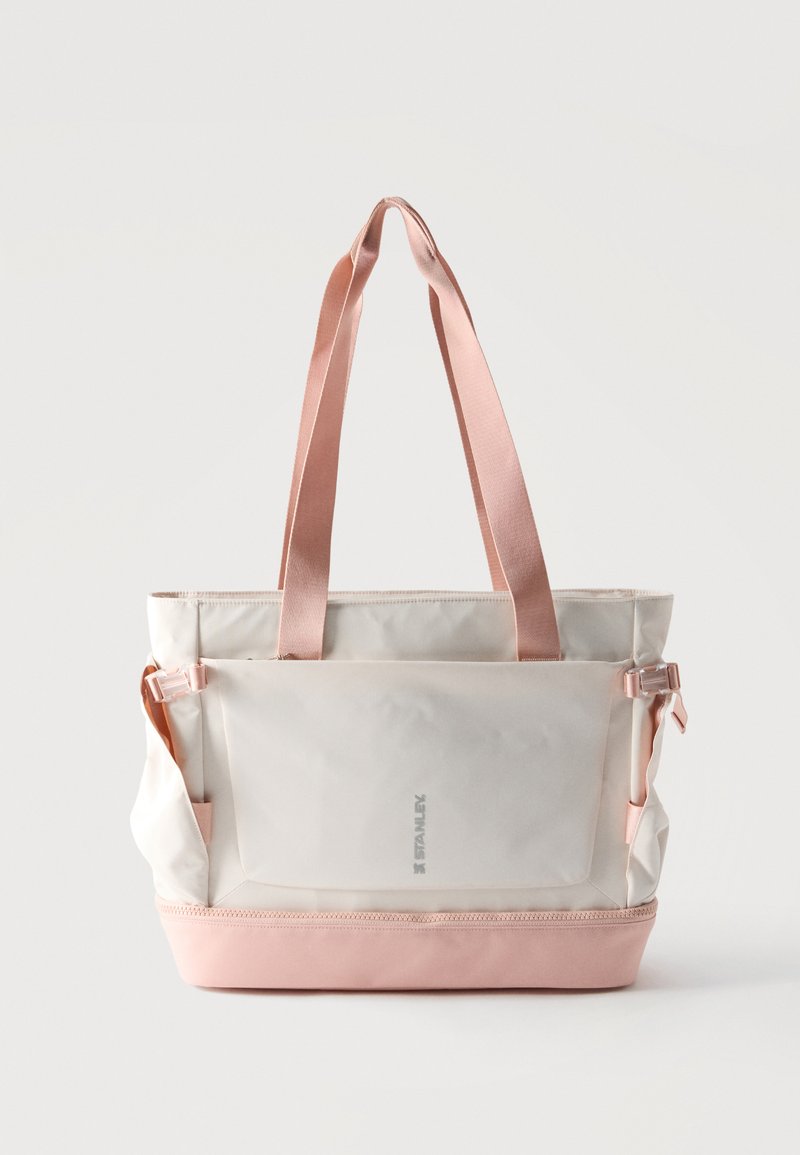 Τσάντα tote σε κρεμ και απαλό ροζ με ρυθμιζόμενους ιμάντες, μπροστινή τσέπη και φερμουάρ στον κάτω χώρο, με την επωνυμία "Stanley" μπροστά.