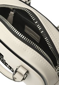 Borsa a tracolla grigia chiara con una finitura testurizzata, foderata in tessuto nero e dotata di doppie compartimenti con zip; dettagli in metallo argentato.