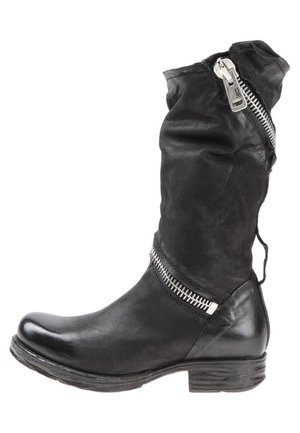 Black mid-calf leather boot with rounded toe, low stacked heel, and silver zippers angled on upper and ankle areas.