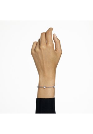 Zilveren armband met drie ronde, heldere kristallen, met een slanke, gebogen vorm, gedragen aan een hand tegen een effen witte achtergrond.