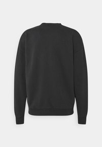 Felpa nera con scollo tondo, maniche lunghe e polsini a costine. Texture del tessuto liscia e design semplice, senza adornamenti.