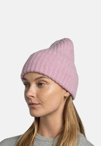 Pink ribbed knit beanie with a pointed top, featuring a soft texture. The model wears a gray shirt, highlighting the hat's design.