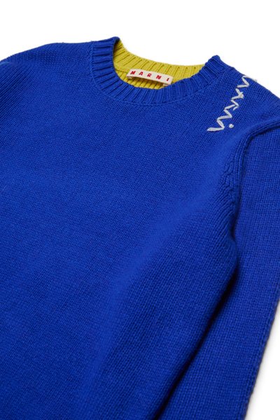 Blå strikkegenser med myk tekstur, rund hals, grønn ribbestrikket krage og hvitt brodert logo på skulderen.