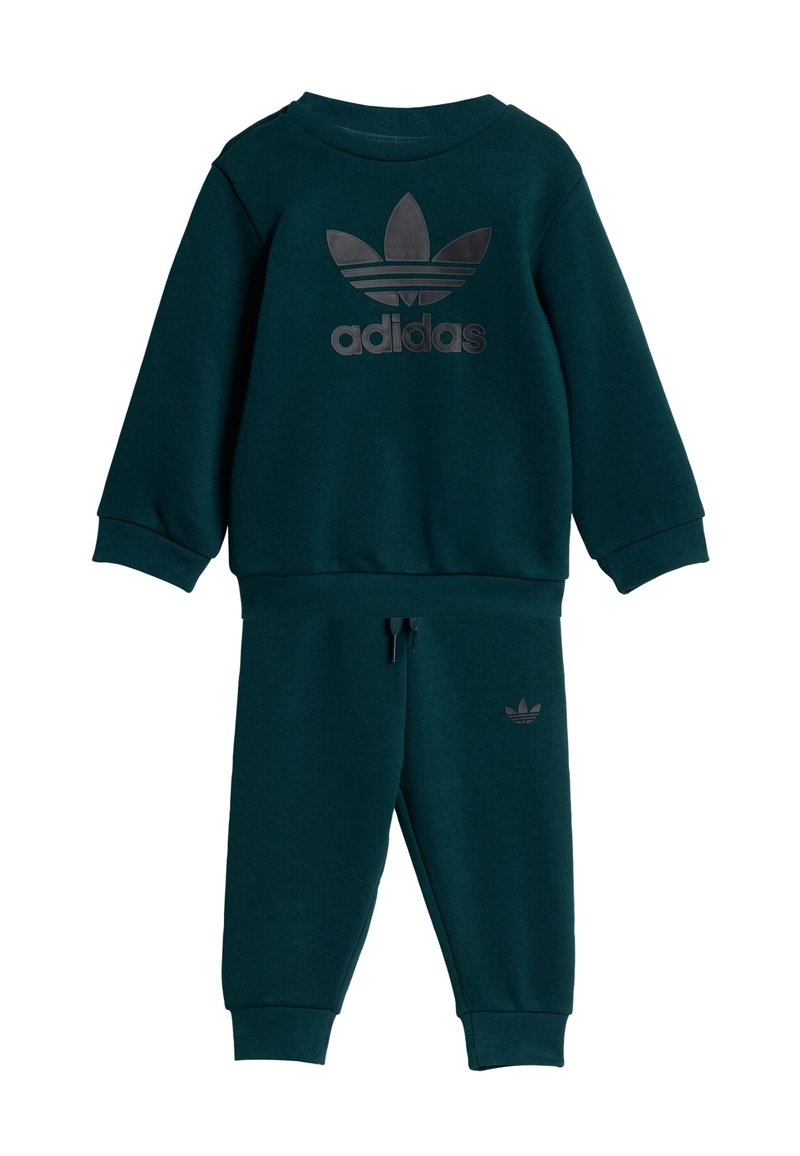 Tumši zaļš Adidas sporta uzvalks, kas izgatavots no mīkstas auduma. Iekļauj kreklu ar apaļu kakla izgriezumu un melnu logo, kā arī atbilstošus bikses ar elastīgām malām.